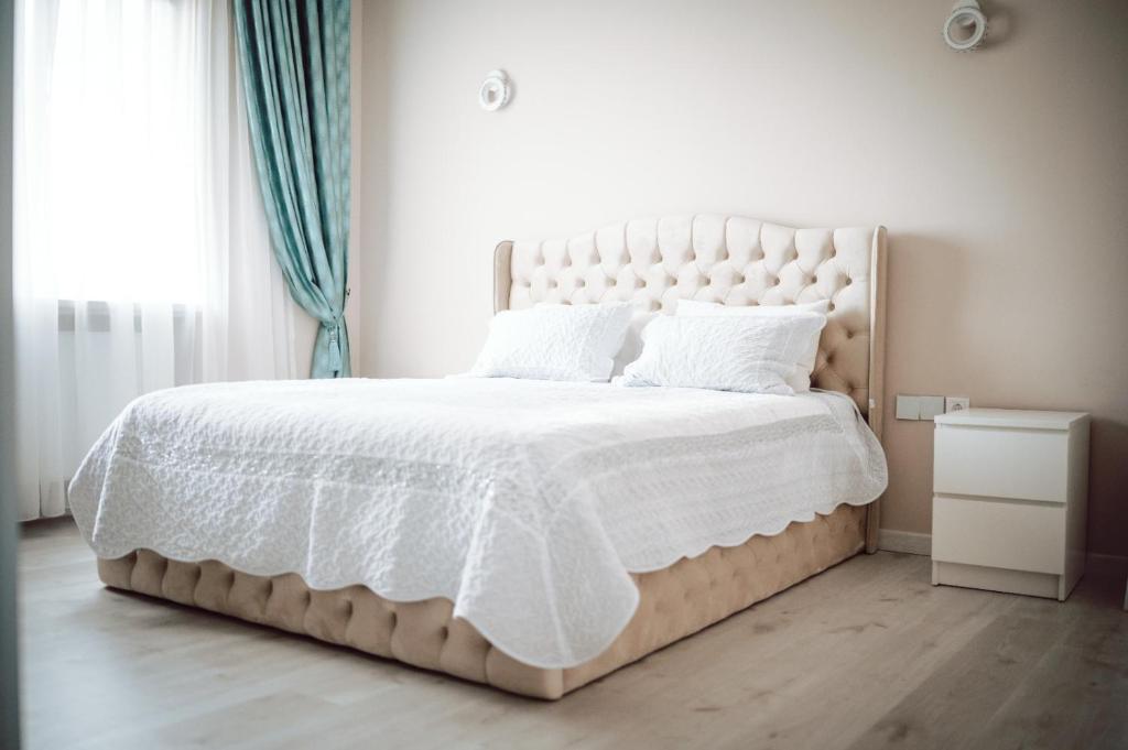 a white bedroom with a large bed with white sheets and pillows at Apartament Ploiesti Central in Ploieşti