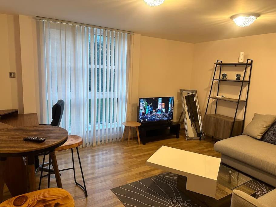 sala de estar con sofá y TV en Specious apartment In Canning Town ( London ), en Londres
