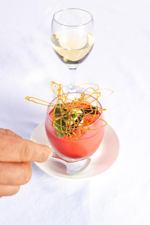 a person pointing at a glass of wine and a bowl of plants at Zanzibar Queen Hotel in Matemwe