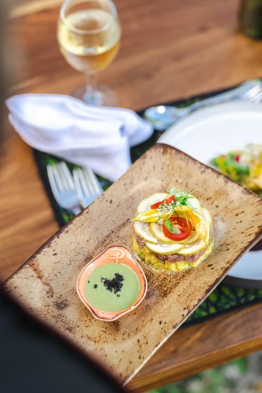 a plate of food on a table with a glass of wine at Zanzibar Queen Hotel in Matemwe