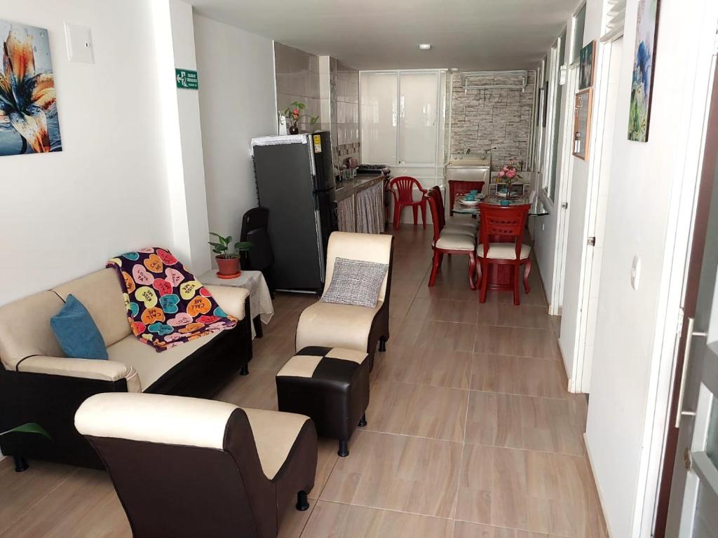 a living room with a couch and chairs and a kitchen at Apto vacacional DENIS T in Tunja