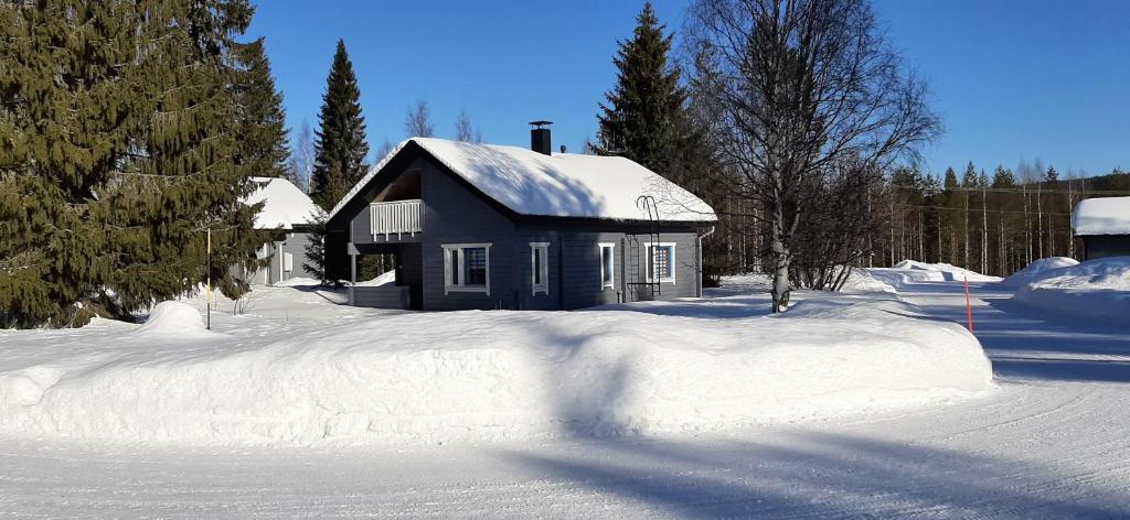 una casa con nieve en el techo en la nieve en Tassutupa, en Hulmi
