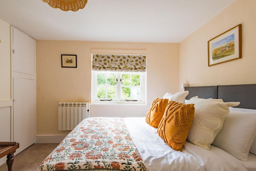 a bedroom with a large bed with a window at Hearts Delight Cottage by Bloom Stays in Bridge