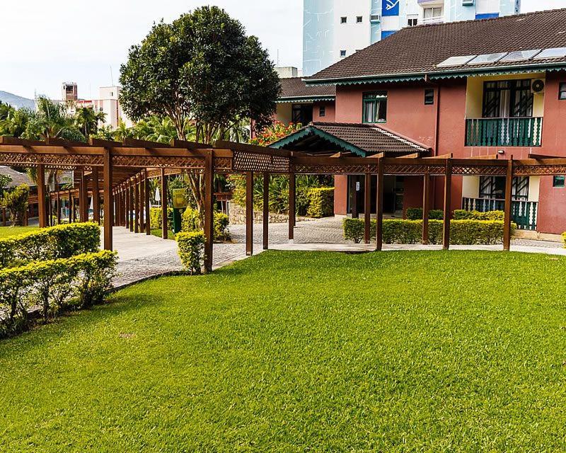 a building with a green lawn in front of it at Spazio Vital Apartments in Florianópolis