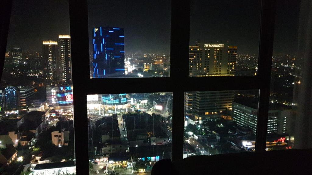 a view of a city at night from a window at Apartemen Grand Jati Junction Unit 3509 in Medan