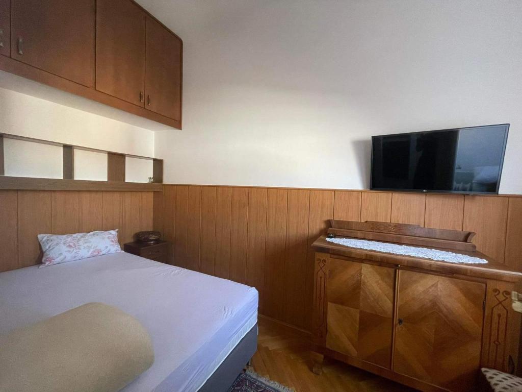 a bedroom with a bed and a flat screen tv at Marietta in Debrecen