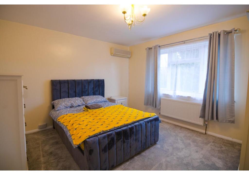 a bedroom with a blue bed and a window at 4 Bedroom Home in Tranquil Gravesend Location in Gravesend