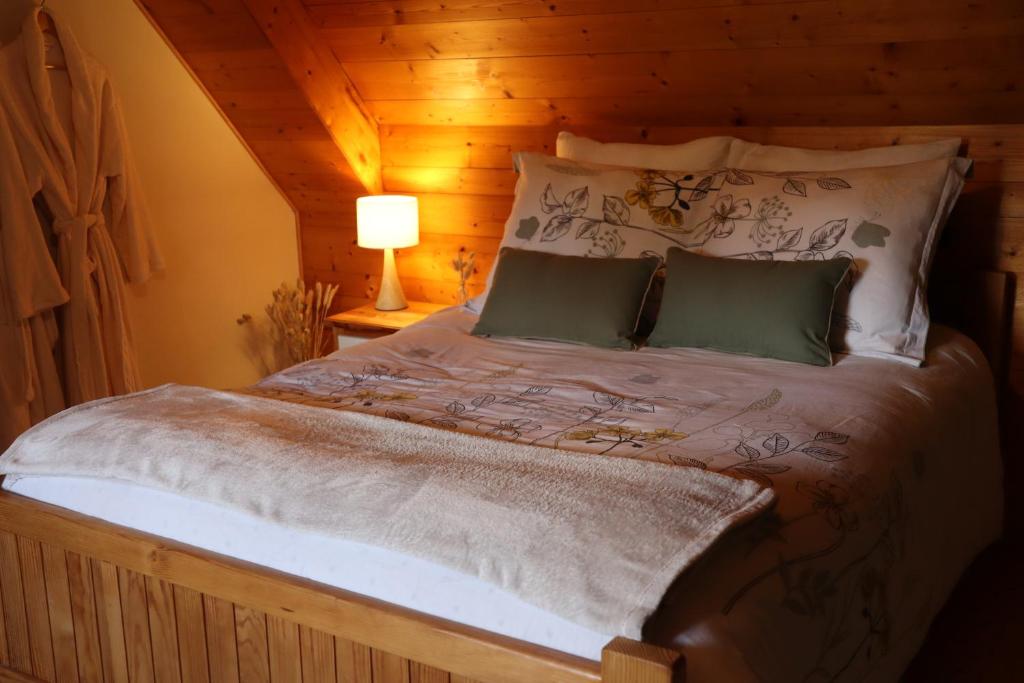 1 dormitorio con 1 cama grande y techo de madera en L'Etang de la Gourdinière, en Landisacq