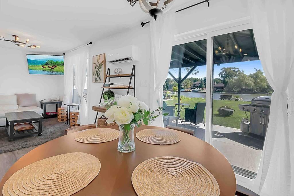une table avec un vase de fleurs dessus dans l'établissement 2 bedroom Getaway on the River/close to marina, à Belle River