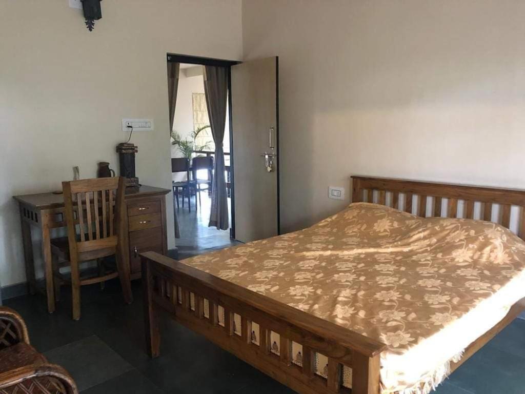 um quarto com uma cama, uma secretária e uma cadeira em Elim-A Sedate Nest em Santiniketan
