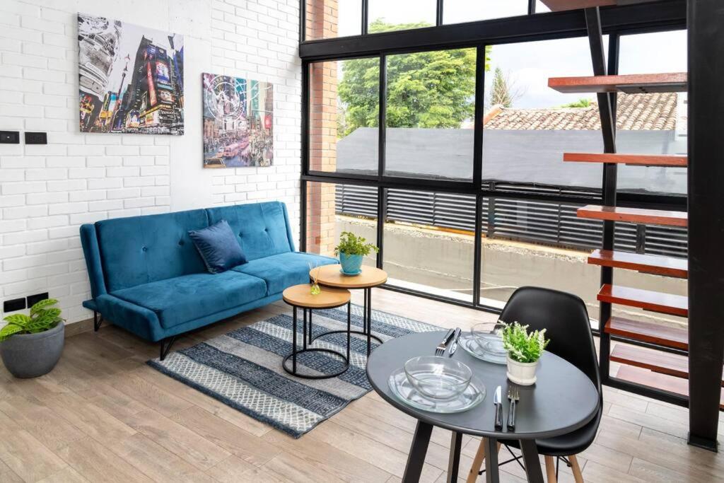 a living room with a blue couch and a table at Hermoso Loft en la flora 205 in Cali