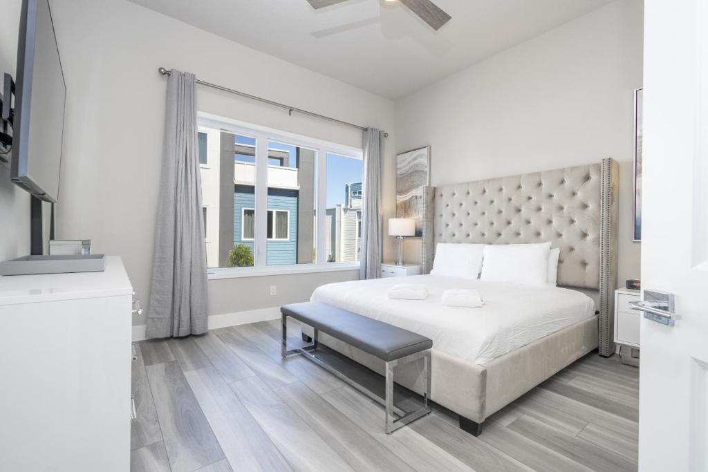 - une chambre blanche avec un grand lit et une fenêtre dans l'établissement 5BR Brand new Apartment Near Disney and Universal, à Kissimmee
