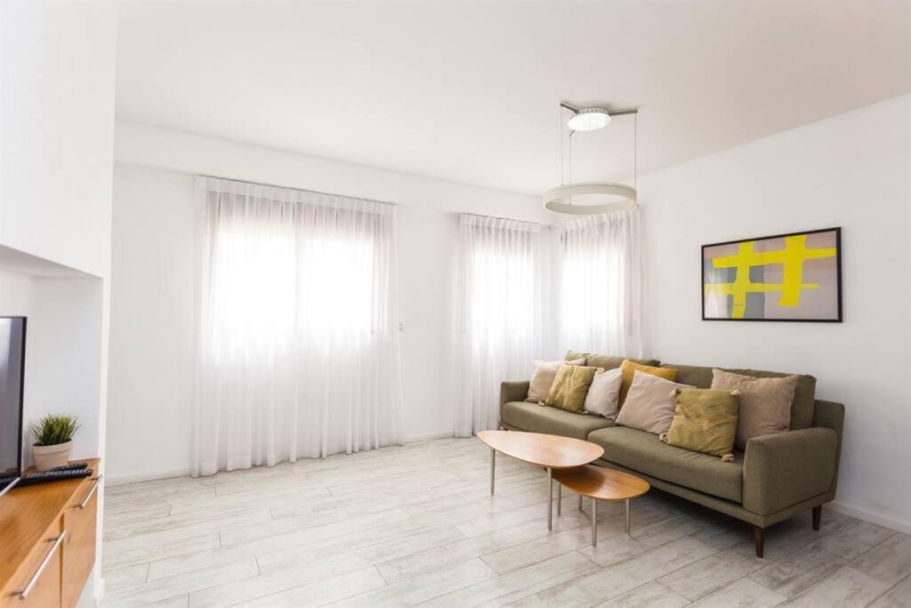 uma sala de estar com um sofá e uma mesa em 2Bedroom Suite with Balcony YonaHotel em Tel Aviv