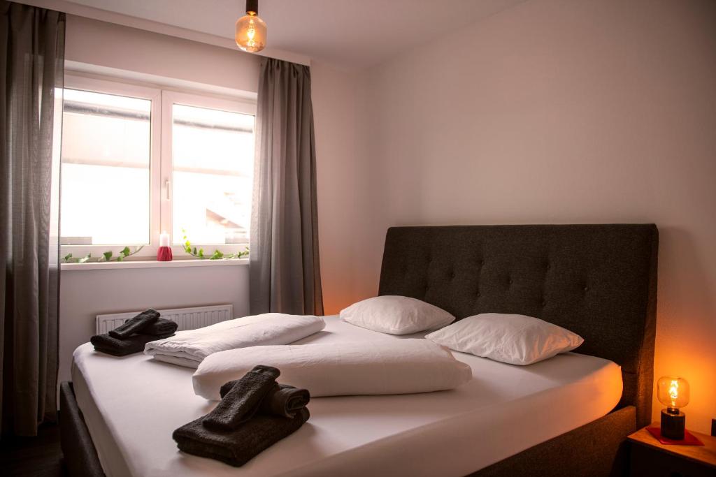 a bed with two towels on it with a window at bergfried - Designwohnung mit Weitblick in Fulpmes