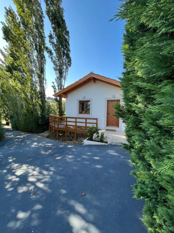 ein kleines weißes Haus mit einer Bank in einer Einfahrt in der Unterkunft Casa Gil, Quinta Carmo - Alcobaça/ Nazaré in Alcobaça
