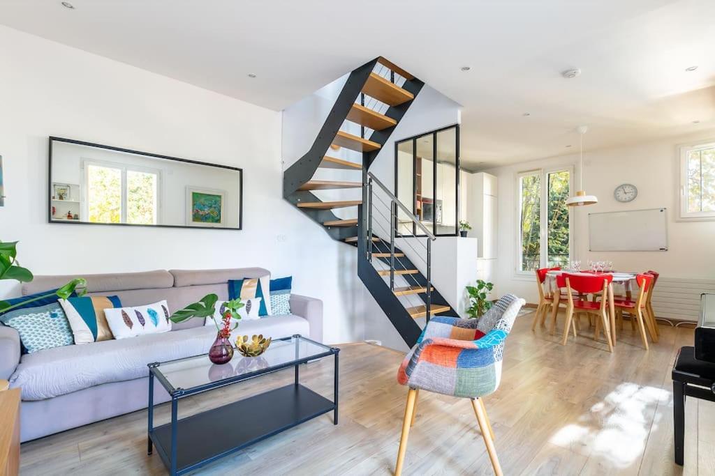 un salon avec un canapé et un escalier dans l'établissement Maison 3 chambres aux portes de Paris, à Arcueil