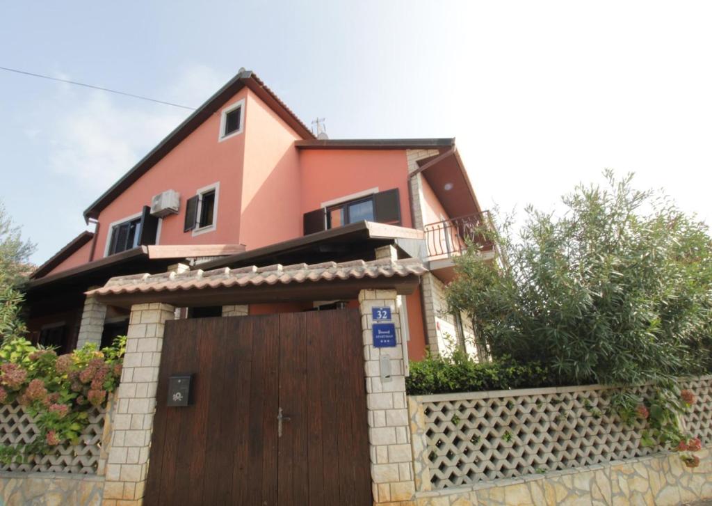 a house with a wooden gate and a fence at Apartment Vera in Zambratija