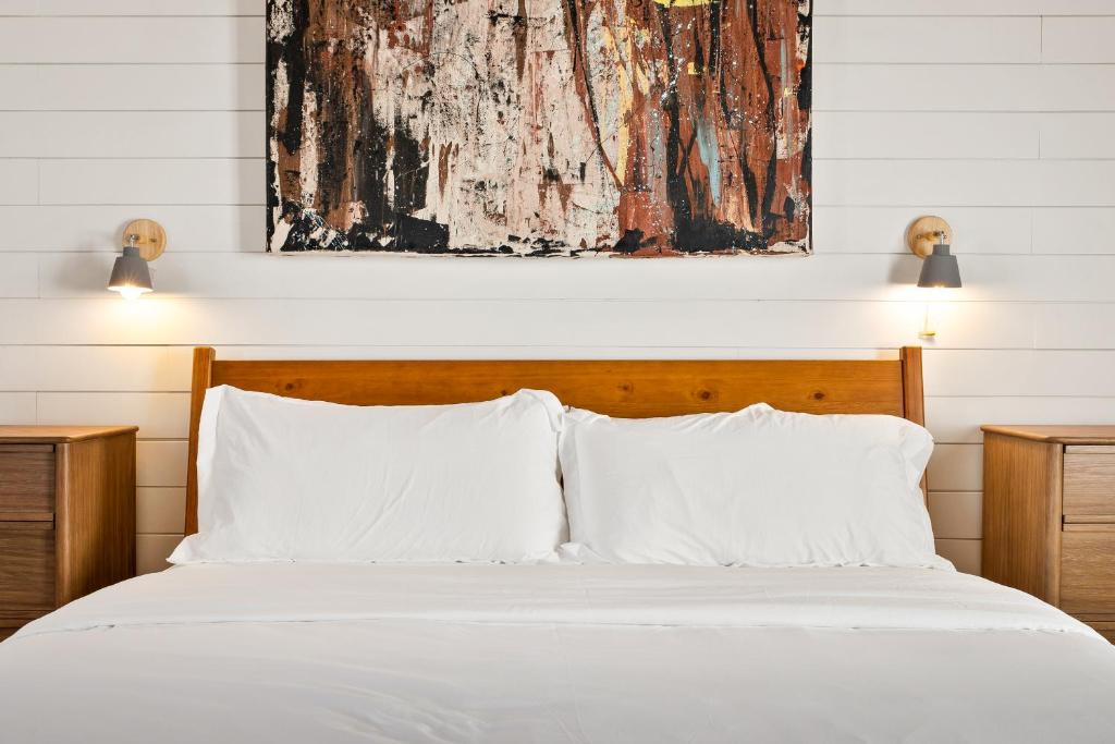 a bed with white pillows and a painting above it at Boutique Room steps from Downtown Mall Rose Jean - Room 4 in Charlottesville