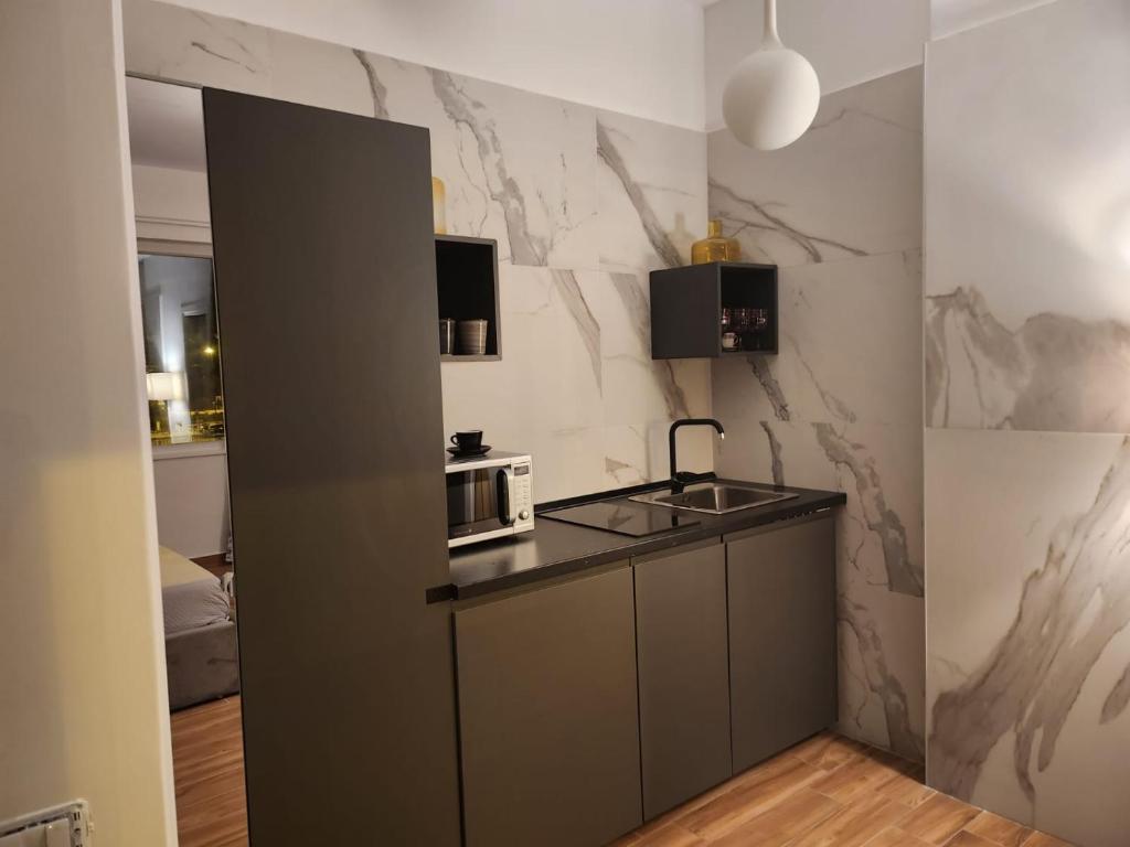 una pequeña cocina con fregadero y microondas en Holding House, en Salerno