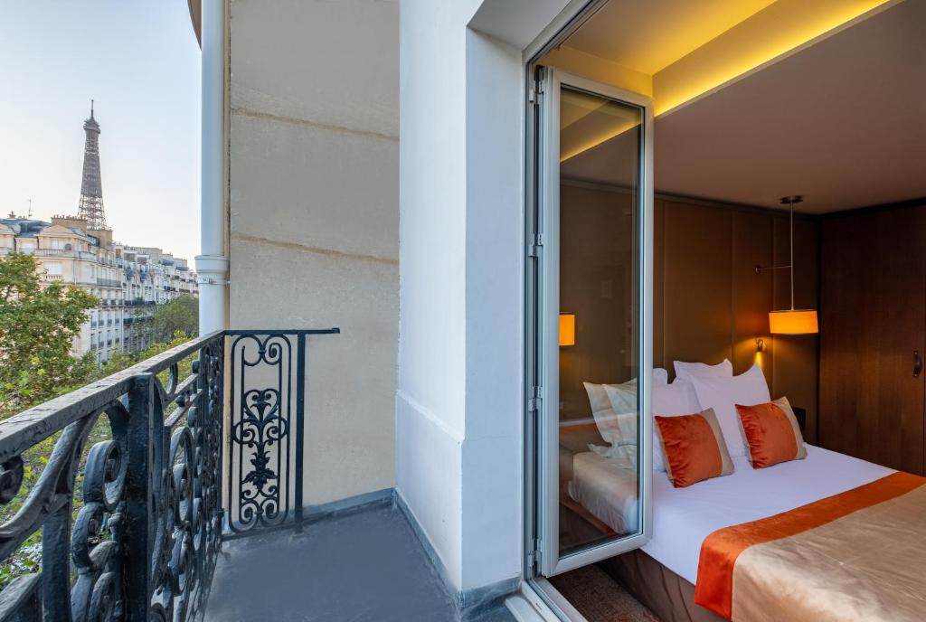 a balcony with a bed and a view of the eiffel tower at Hôtel La Bourdonnais by Inwood Hotels in Paris