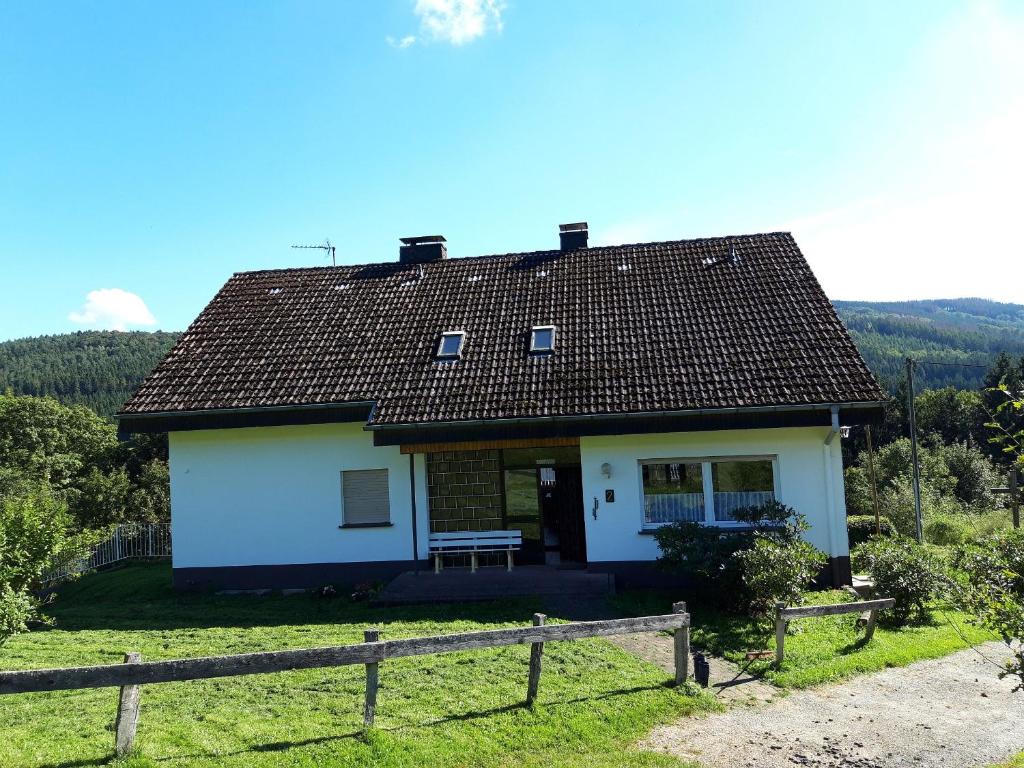 una pequeña casa blanca con una valla de madera en Haus Anna, en Kirchhundem