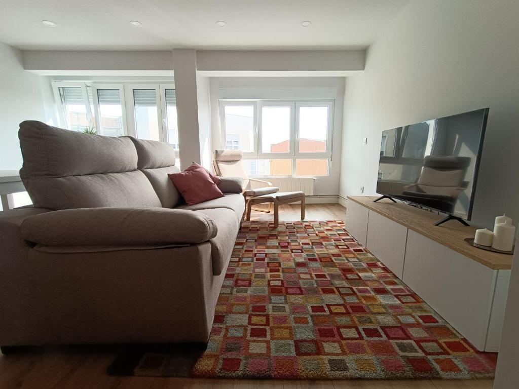 サンタンデールにあるPrecioso Apartamento Nuevo Céntrico en Santanderのソファと薄型テレビのあるリビングルーム