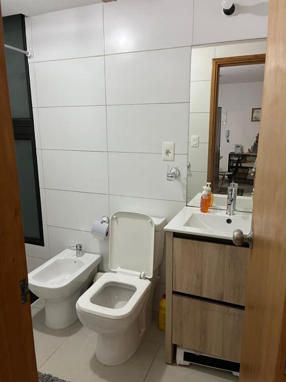 een witte badkamer met een toilet en een wastafel bij Edificio DaLuis in Punta del Este