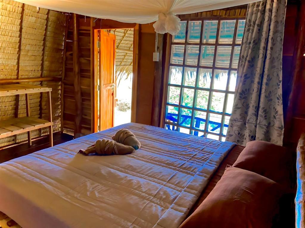 a bedroom with a large bed with a large window at Lanta Marina Resort By Mam&Mod in Ko Lanta