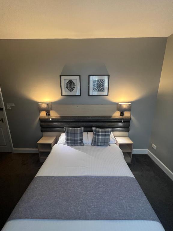 um quarto com uma cama grande e 2 almofadas em Holborn Hotel em Thurso