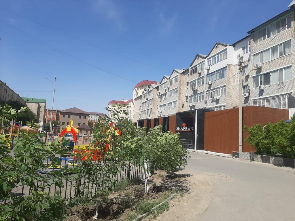 een straat met gebouwen en bomen en een hek bij 2-комнатная квартира в центре города in Atıraw