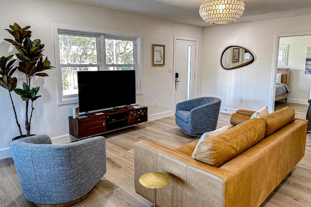 uma sala de estar com um sofá e duas cadeiras e uma televisão em The Palmetto Paradise em Saint Augustine
