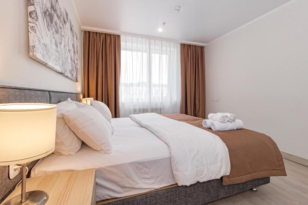 Un dormitorio con una cama grande con un animal de peluche. en Apart-hotel Ye,s Astana, en Taldykolʼ