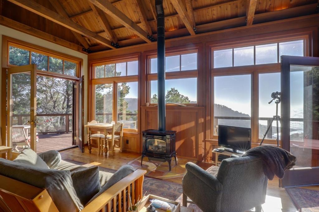 a living room with a fireplace and a stove at Romantic Ridgetop Escape with Hot Tub Near Mendocino in Albion