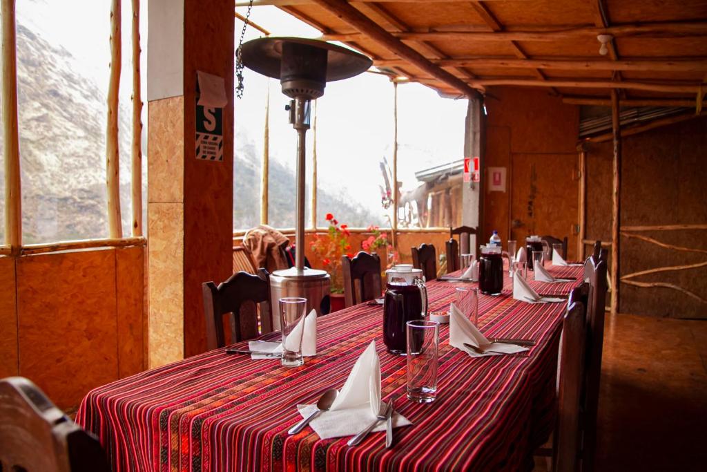 a row of tables with napkins on them in a restaurant at Refugios Salkantay - "StaySoraypampa - Accommodation near Humantay Lake and Salkantay Trek" in Cusco