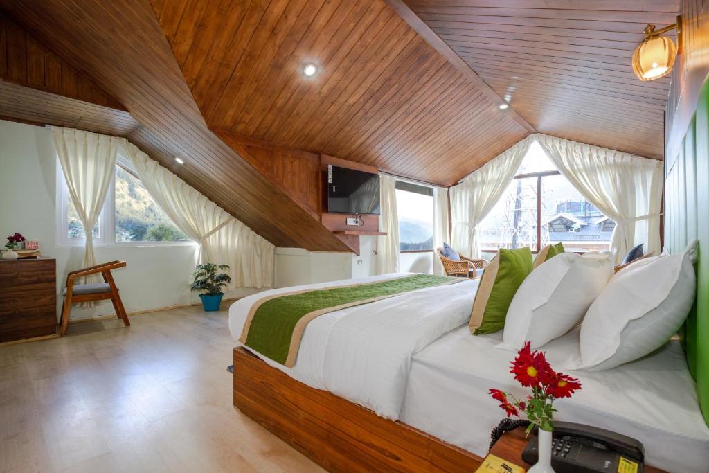 a bedroom with a large bed in a wooden ceiling at Tripli Hotels Drilbu Manali in Manāli