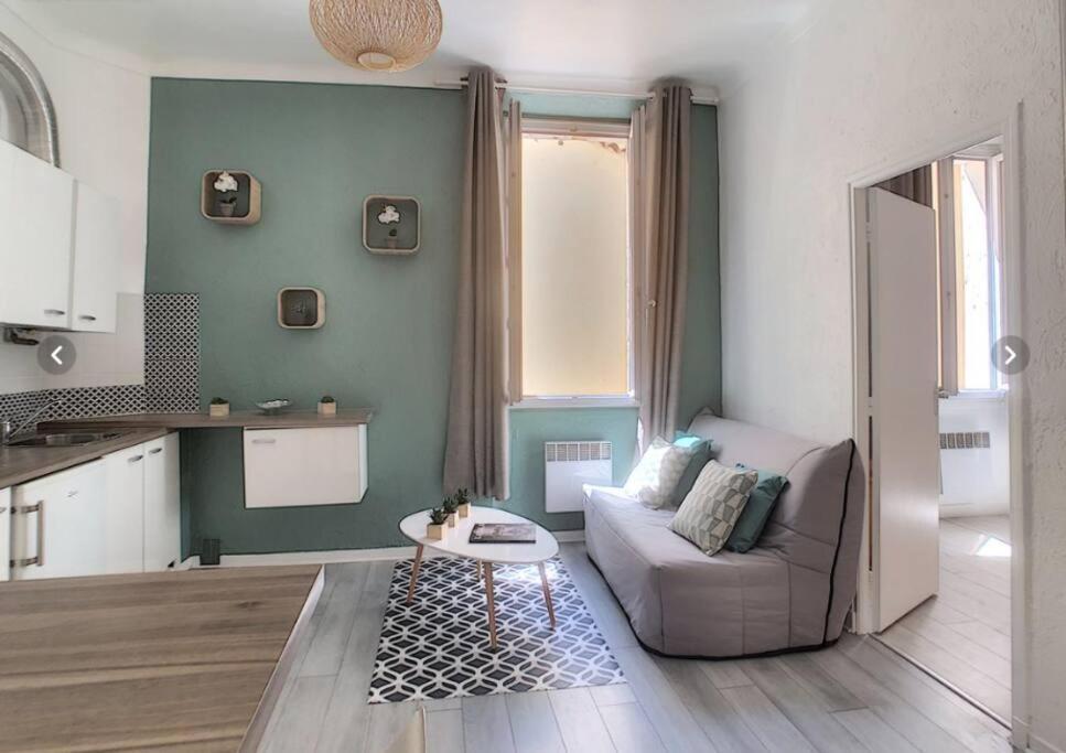 un salon avec un canapé et une table dans l'établissement Appartement Canne 1 chambre - 21JOFFRE, à Cannes