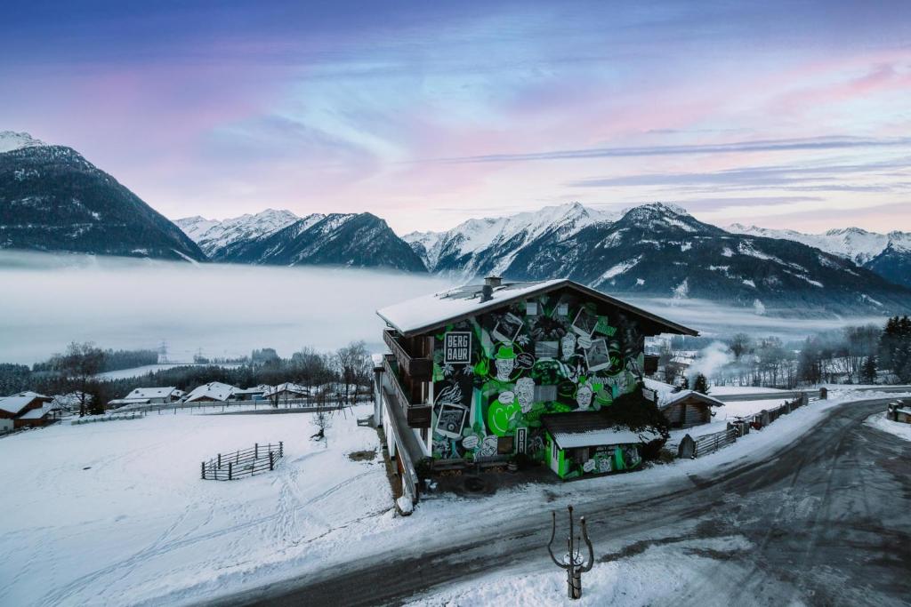 ein kleines Haus im Schnee mit Bergen im Hintergrund in der Unterkunft BergBaur in Neukirchen am Großvenediger