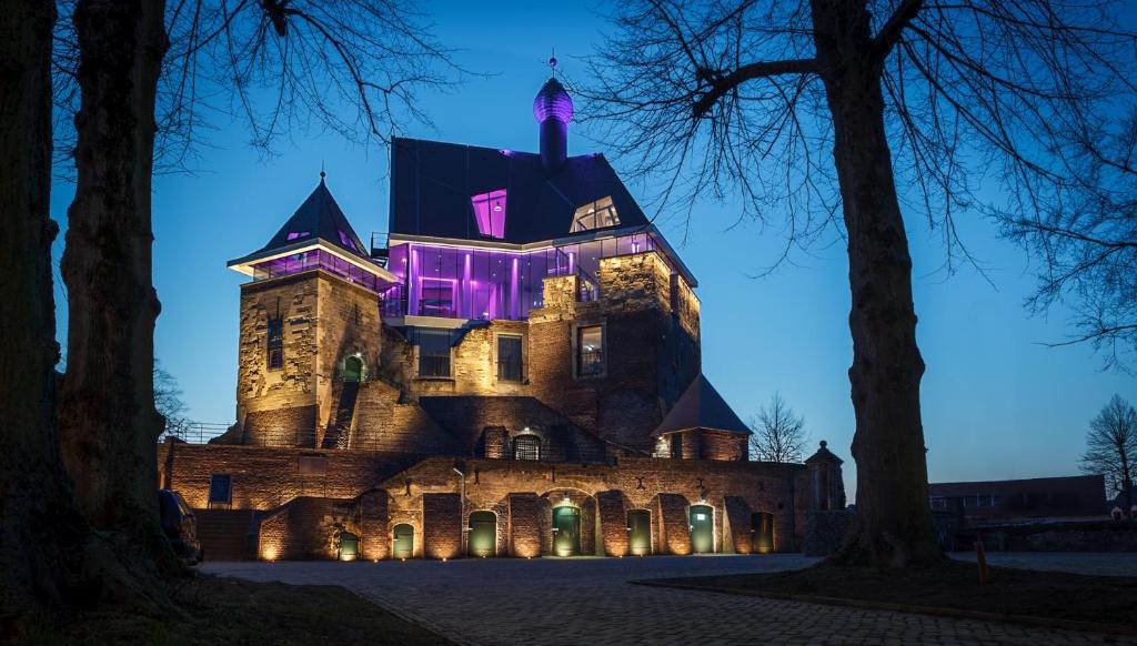 een kasteel wordt 's nachts verlicht met paarse lichten bij Klein Veers in Kessel