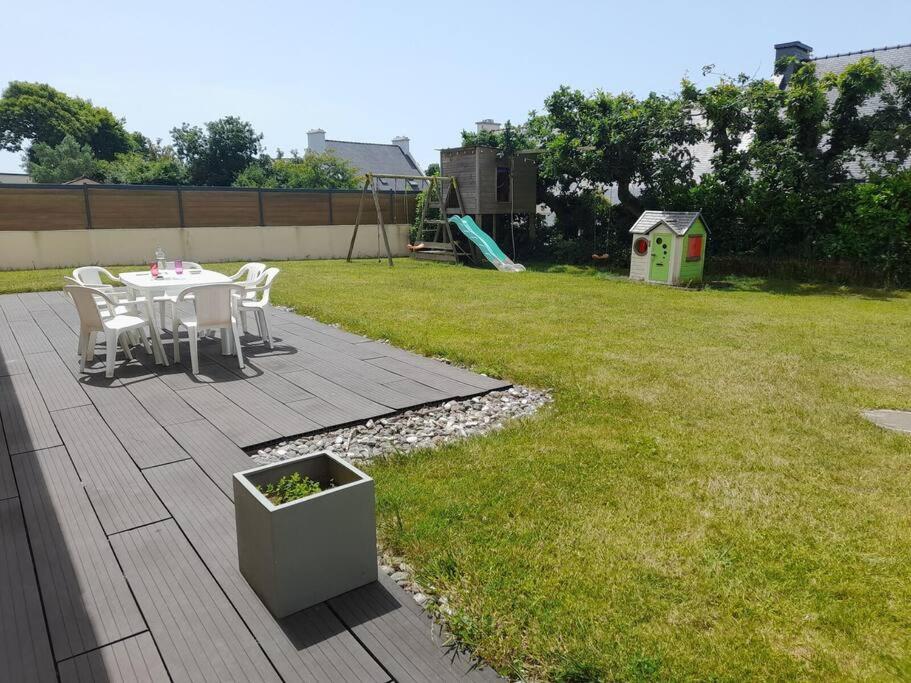 a patio with a table and chairs in a yard at Ty Colo ✿ maison familiale classée, proche Brest in Saint-Renan