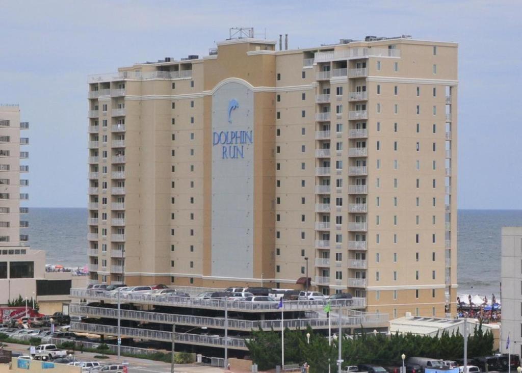 a large tan building with a sign on it at Dolphin Run in Virginia Beach