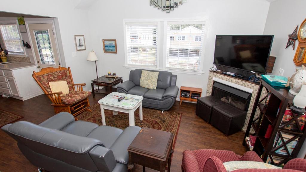 a living room filled with furniture and a flat screen tv at Oceanside, Hot Tub, Close to beach, KD231, WindOver in Kill Devil Hills