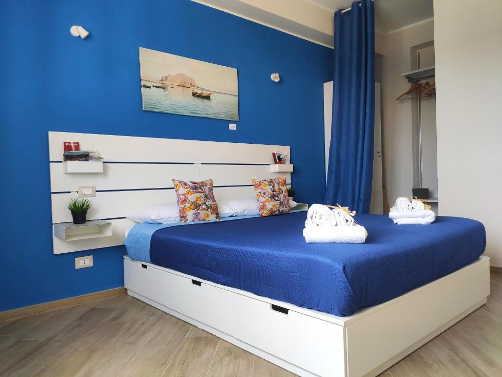 ARTrinacria Apartments - Qubba في باليرمو: غرفة نوم زرقاء مع سرير بجدران زرقاء