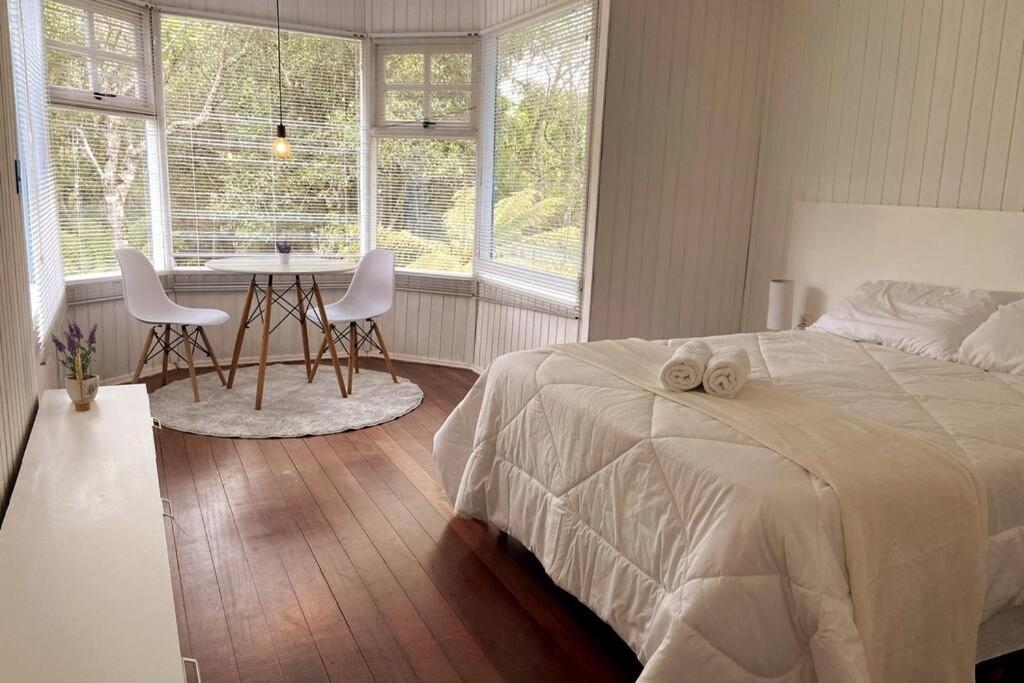 a bedroom with a bed and a table and chairs at Blue House em Condomínio Fechado in Gramado