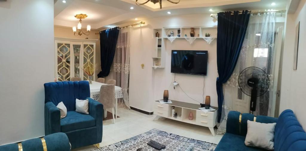 a living room with a blue couch and a tv at الإسكندرية طوسون شارع المستشارين بجوار فتح الله ماركت in Abū Qīr