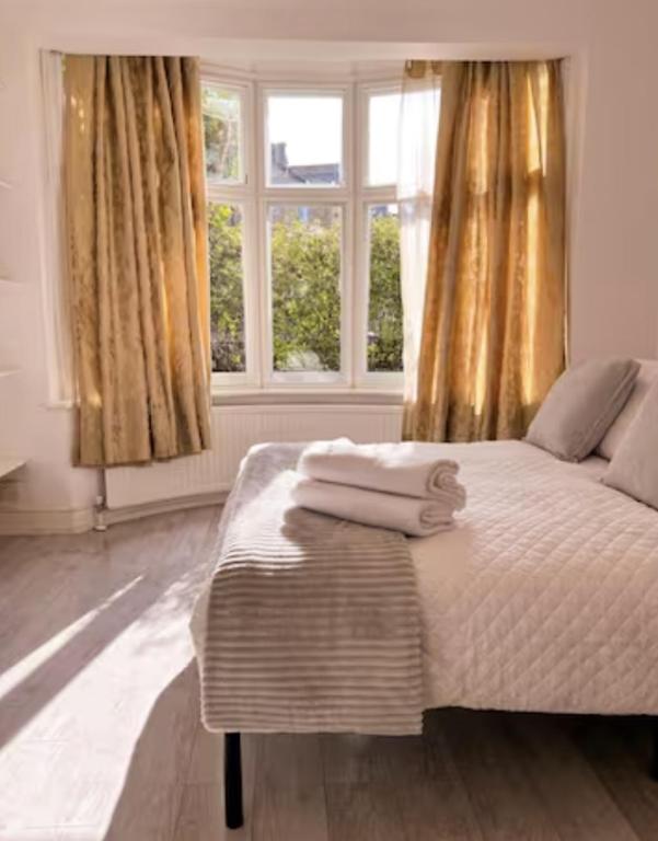 a bedroom with a bed with two towels on it at Comfy double room in Clapham in London