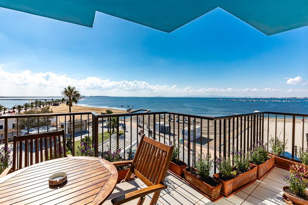 een balkon met een tafel en uitzicht op het strand bij Encantador apartamento con vistas al mar y AC in San Pedro del Pinatar