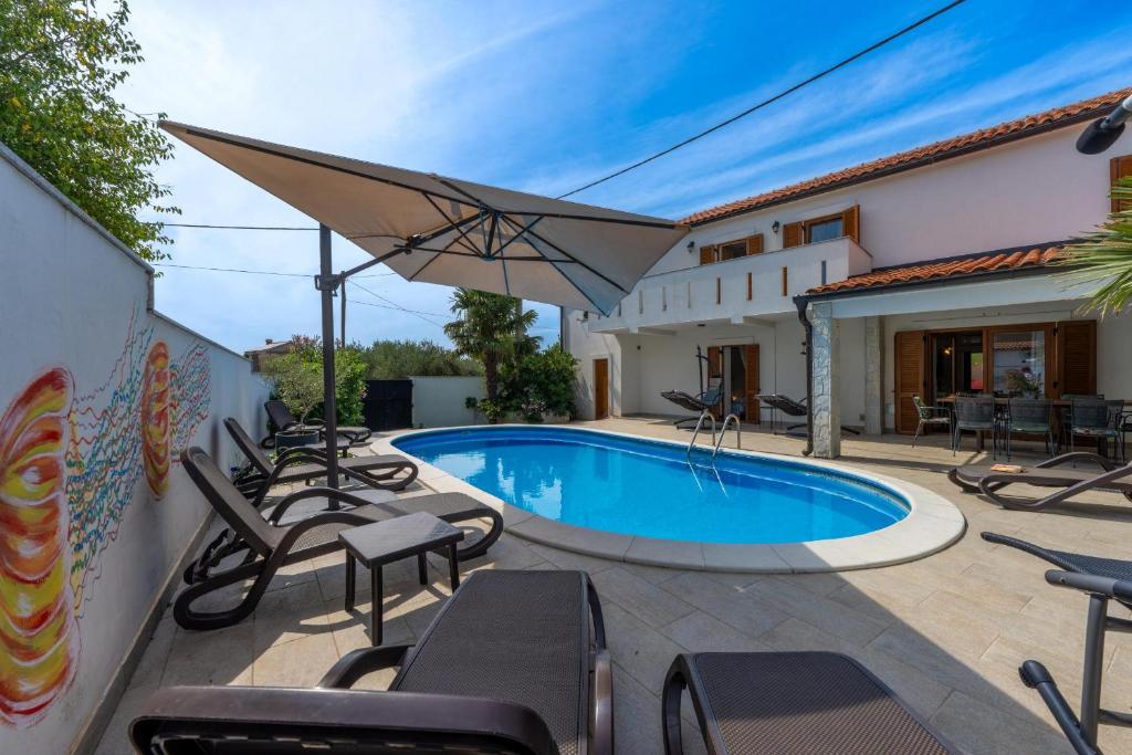 a villa with a swimming pool and patio furniture at Villa Goldie in Polje