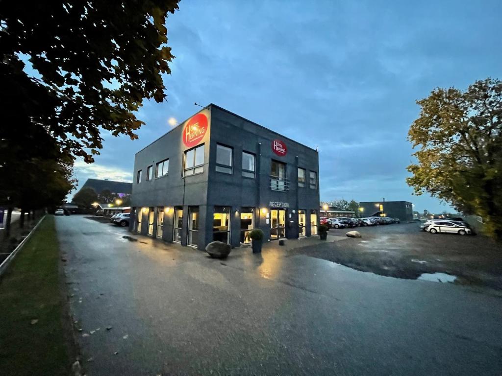 un bâtiment situé sur le côté d'un parking dans l'établissement Hotel Herning, à Herning