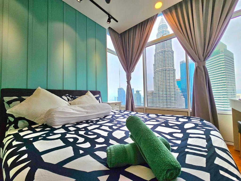 a bedroom with a green and white bed with a large window at De Sky Suites KLCC Kuala Lumpur in Kuala Lumpur