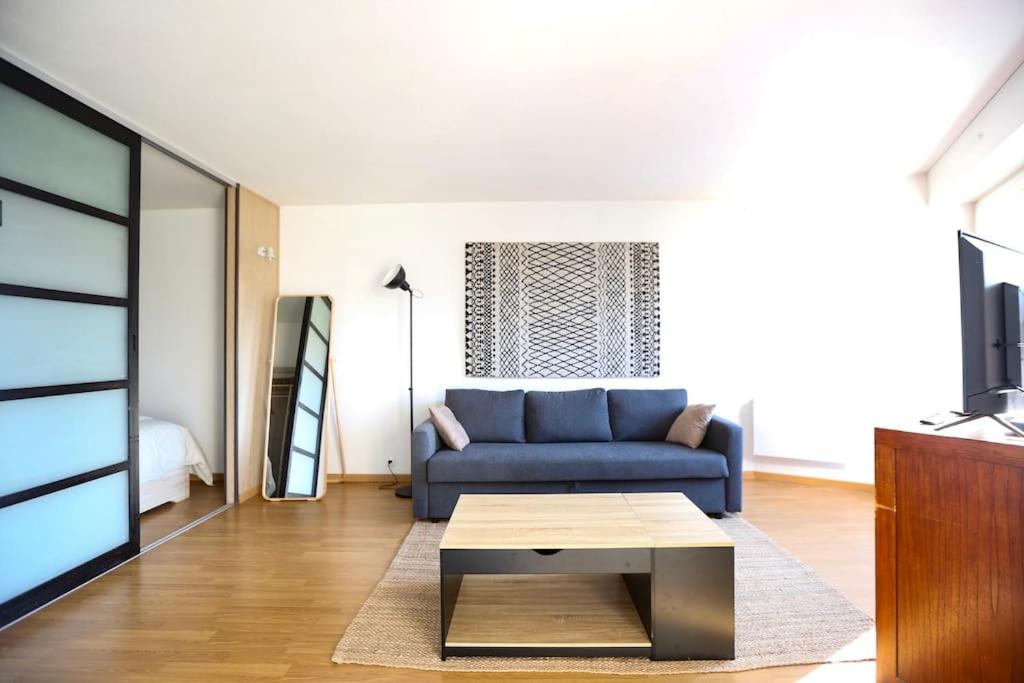 - un salon avec un canapé bleu et une table basse dans l'établissement Special Loft : 40 m² de confort, à Cergy